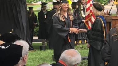 Graduate shakes hands with Dr. Allen and accepts her diploma